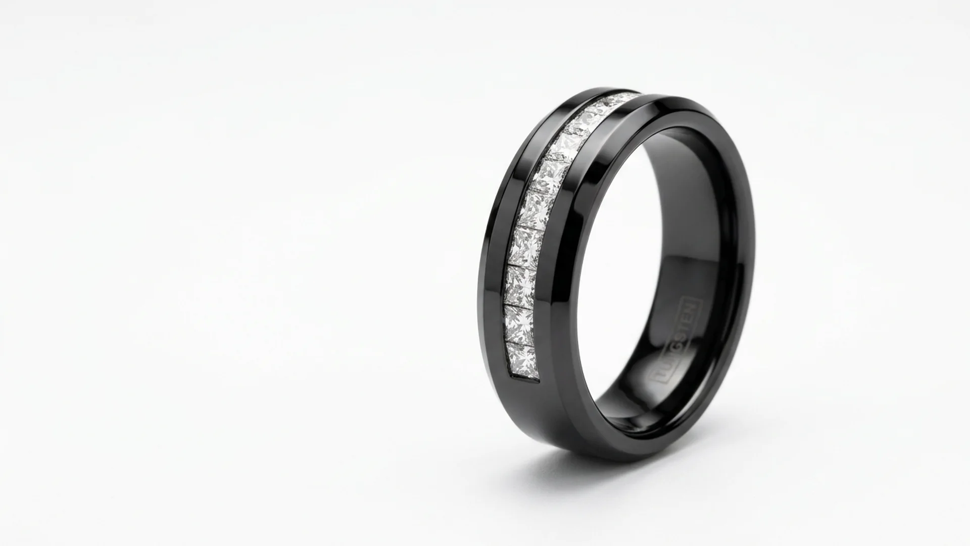Black tungsten ring with channel-set diamonds on marble